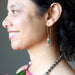 woman wearing malachite and rhodochrosite gold earrings
