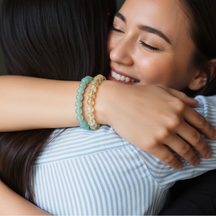 Two people embracing, with one person wearing two beaded bracelets on their wrist.