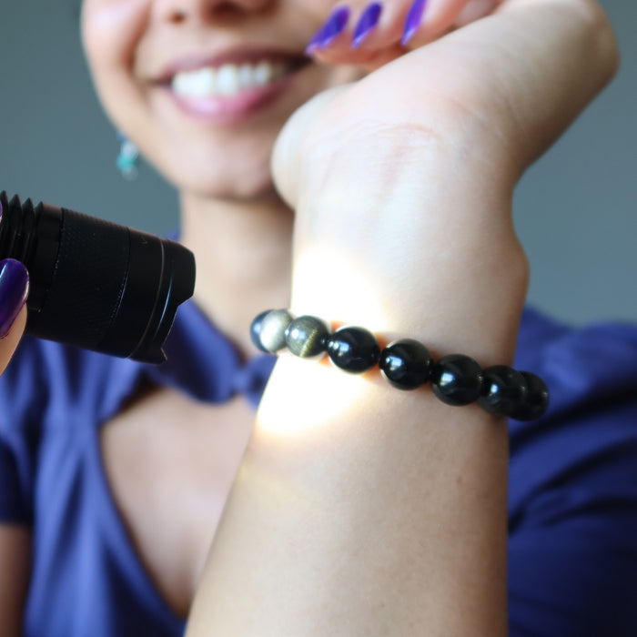 gold sheen obsidian bracelet under light