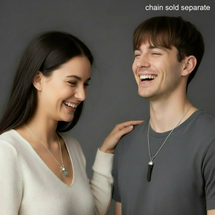 Two people laughing together against a gray background