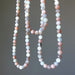 Two strands of multicolored beaded Moonstone Necklaces on a gray background