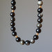 Gold Sheen Obsidian necklace  with black and gray beads on a gray background