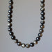 Gold Sheen Obsidian beaded necklace  with dark beads on a plain background