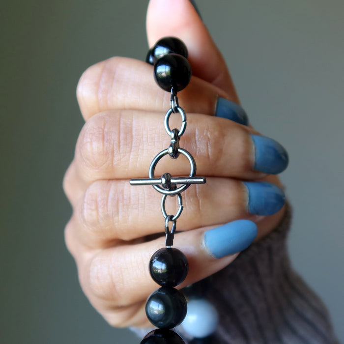 Necklace with alternating black obsidian and light blue angelite beads and toggle clasp
