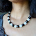 Rainbow Obsidian Snow Quartz necklace with black and white beads worn by a person