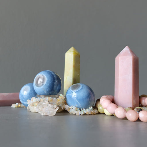 Set of opal crystals including spheres, a tower, and a pink crystal on a gray background