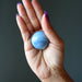 blue opal sphere in palm of hand