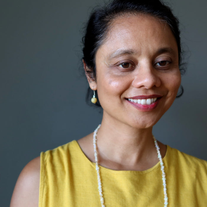 Woman wearing Yellow Opal earrings with a gray background
