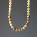 Opal necklace with multicolored beads on a gray background