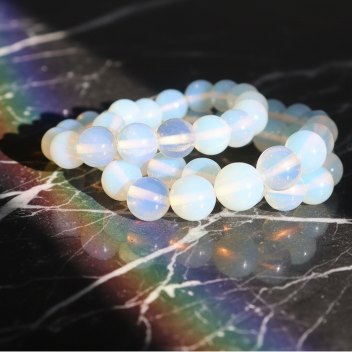 Opalite beads on a dark surface with rainbow