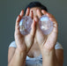 Person holding two Amethyst crystal ovals against a neutral background