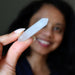 Person holding a clear quartz doubleterminated  with a blurred background