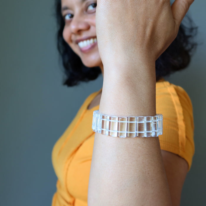 Woman wearing a Clear Quartz bracelet on her wrist with a blurred background