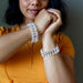 Person wearing two clear Clear Quartz bracelets on a neutral background