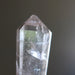 Clear quartz crystal wand on a dark background