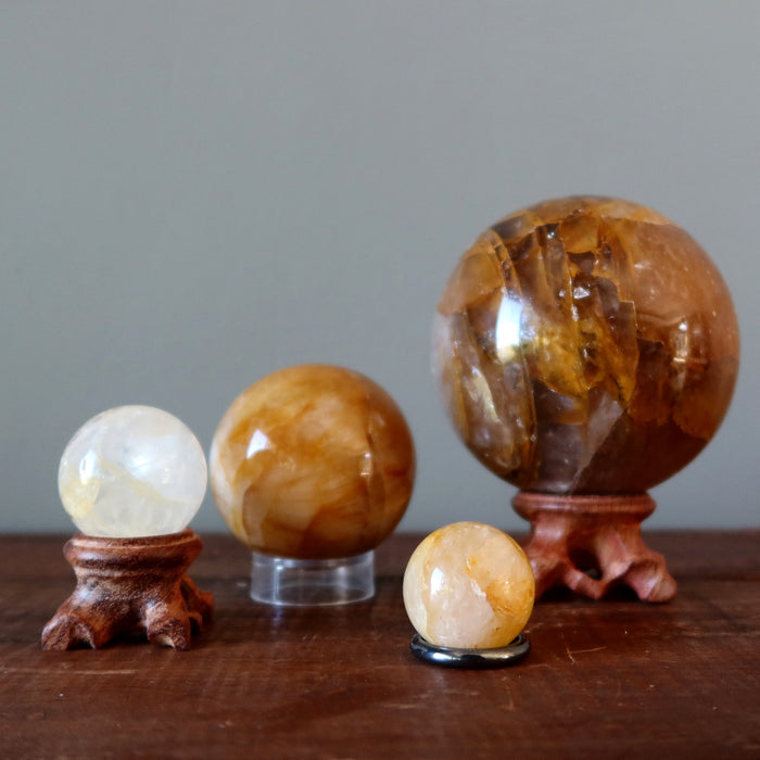 golden healer quartz spheres in different sizes on stands