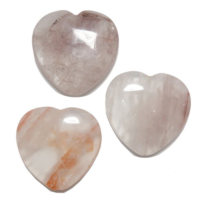 Three heart-shaped Quartz stones on a white background
