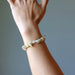 Rutilated Quartz bracelet on a wrist against a neutral background