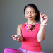 woman meditating with rhodochrosite stones