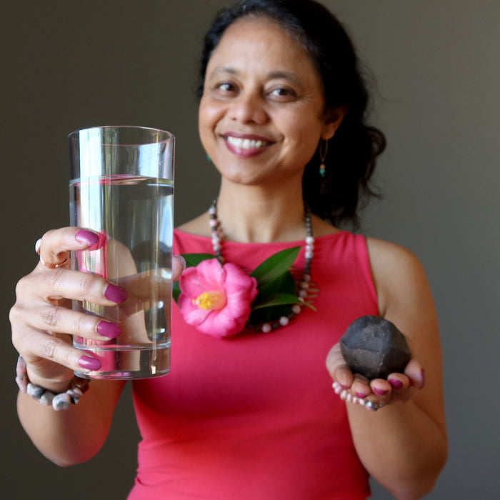 woman holding water and moqui marble