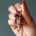 hand holding rhodonite earrings
