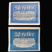 Two vintage German banknotes with blue and white design on a dark background