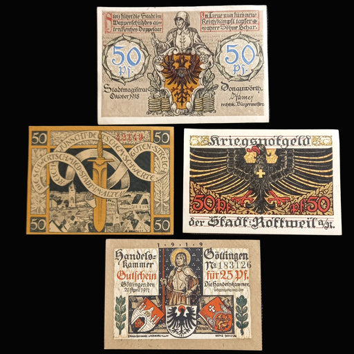 Collection of vintage pfennig german notgeld banknotes with intricate designs and text on a dark fabric background.