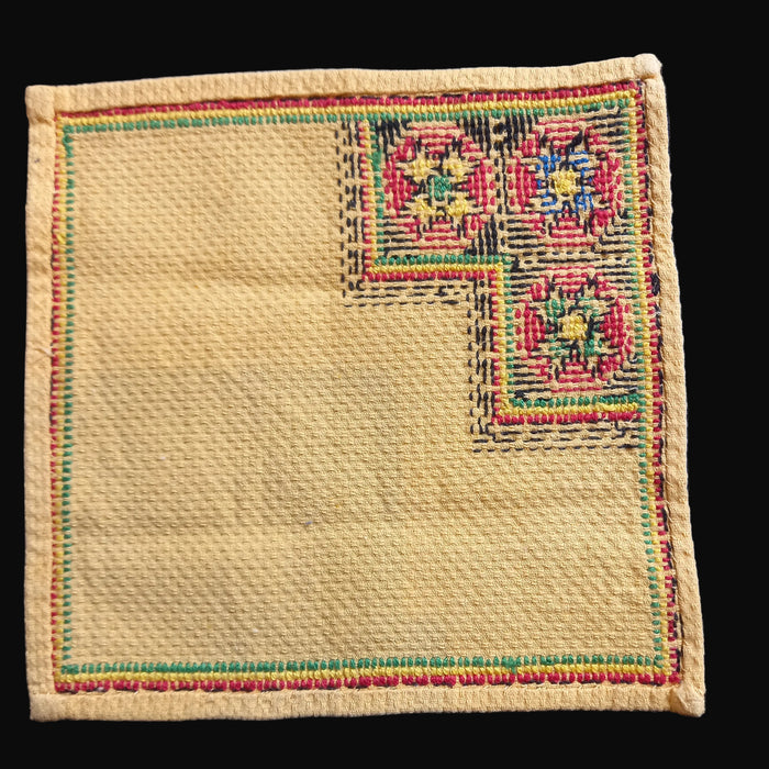 Beige embroidered fabric patch with geometric star patterns from Great Plains of Hungary on a dark background