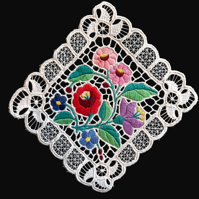 Decorative lace doily with embroidered flowers on a black background in hungarian kalocsa style