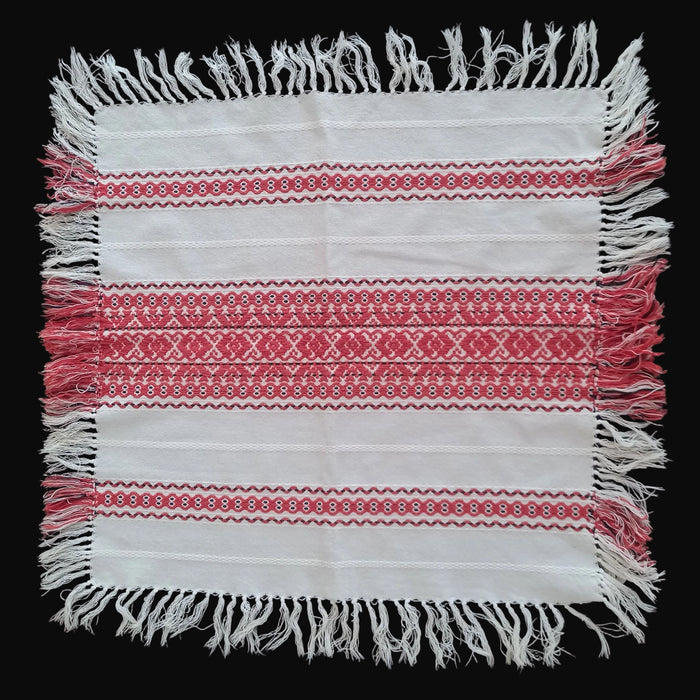Textile with red and white patterns and fringes on a dark background from Hungary Europe