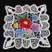 Decorative Hungarian Richelieu Kalocsa doily with embroidered flowers on a black background