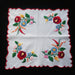 Embroidered floral kalocsa hungarian design on a white fabric with red scalloped edges against a dark background