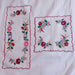 Two embroidered floral designs on a white fabric background