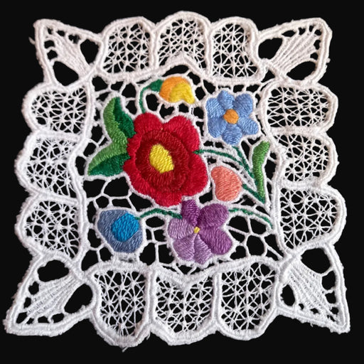 Decorative lace doily with embroidered flowers on a black background from 1970s Hungary
