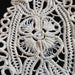 Close-up of intricate lace fabric with a floral design in Transylvanian style on a dark background