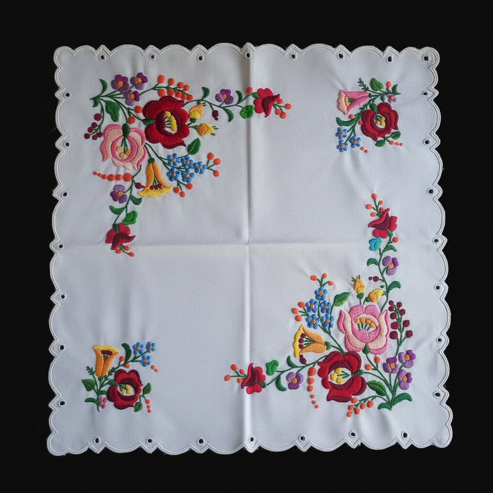 Embroidered floral pattern on a white fabric with a black background
