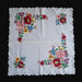 Embroidered floral pattern on a white fabric with a black background