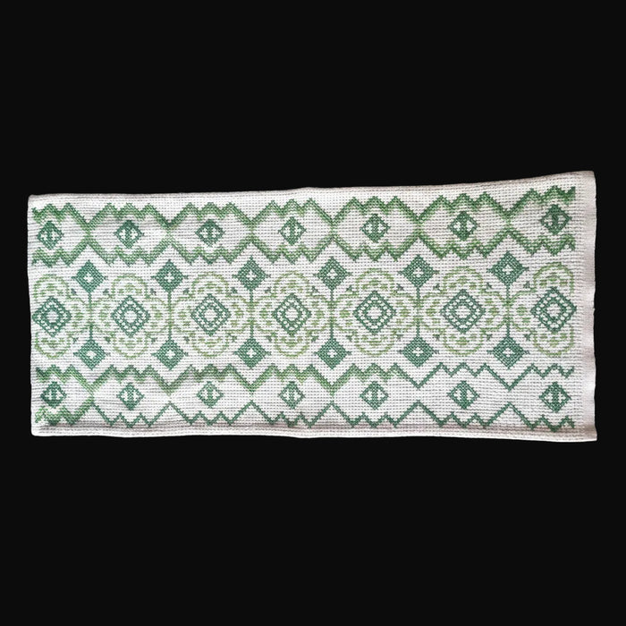 Vintage Hungarian folk art table runner Textile with green geometric pattern on a black surface