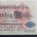 A vintage German 50 Reichsbanknote from August 5, 1914, displayed flat against a dark navy background. The note features a cream-colored paper base with red and blue printed details, black gothic text, and ornate red floral patterns.