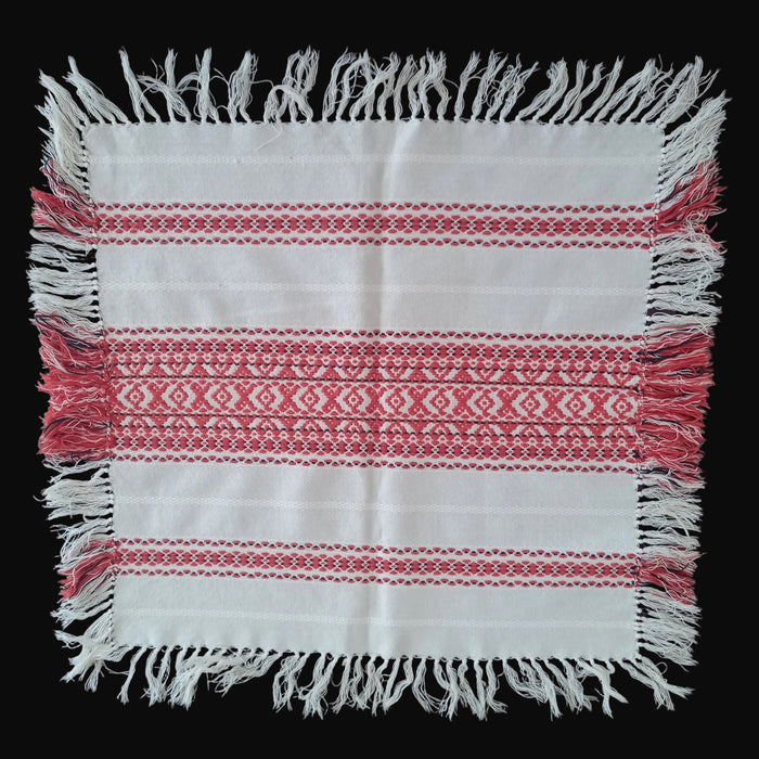 Hungarian folk art table topper, White with red patterns and fringes on a dark background