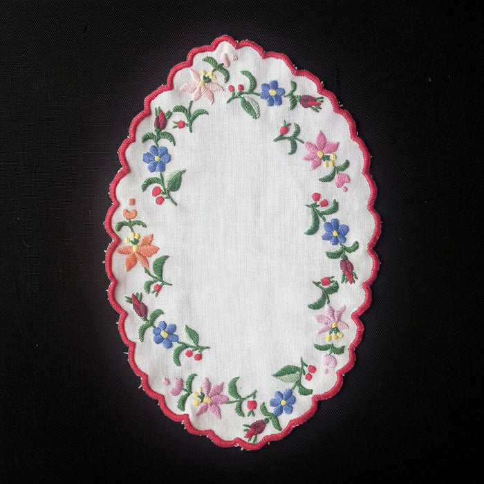 Embroidered Kalocsai Hungarian folk art vintage doily with floral patterns on a black background