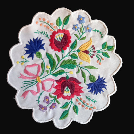 Embroidered table centerpiece hungarian kalocsai style with colorful floral design on a black background