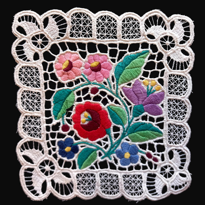 Embroidered floral design with a lace border on a black background