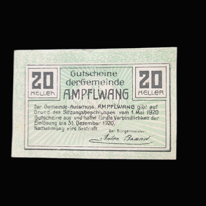 Vintage paper currency from the Gemeinde Ampflwang with text and numbers on a dark background