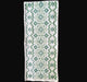 Cross-stitched green pattern on white fabric from Hungary, against a dark background