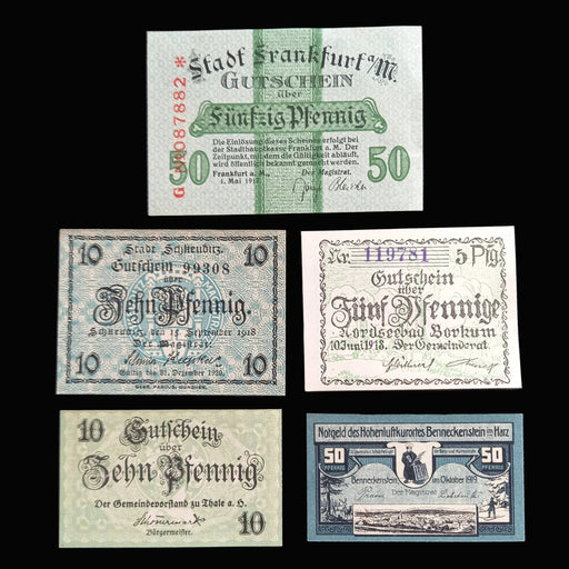 Collection of vintage German notgeld pfennig banknotes on a dark fabric background
