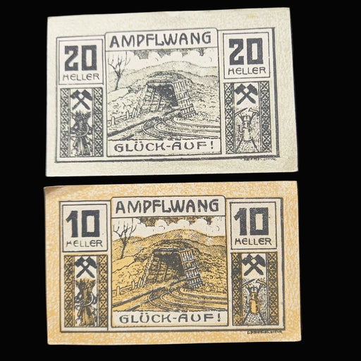 Two vintage banknotes from Ampflwang with text and symbols on a dark background