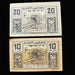 Two vintage banknotes from Ampflwang with text and symbols on a dark background