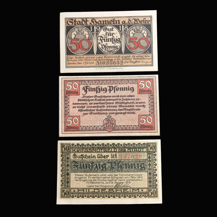 Three vintage German banknotes displayed on a black background