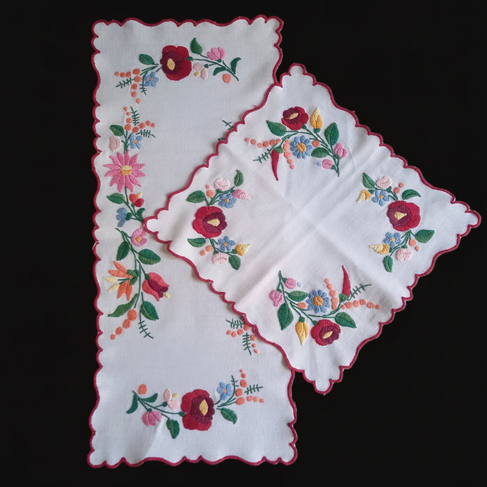Floral embroidered table toppers on a dark surface